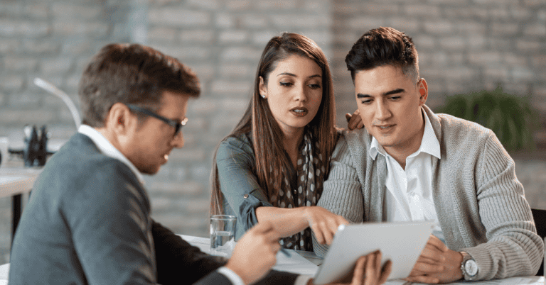 Couple reviewing business loan renewal with financial advisor on a tablet