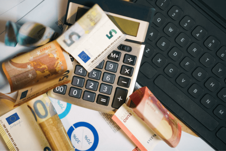 Small business owner reviewing equipment finance costs and payment options with calculator and documents on desk