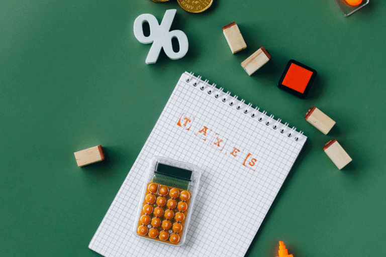 A calculator and a notepad with the word TAXES, illustrating smart ways to maximise deductions for the EOFY.