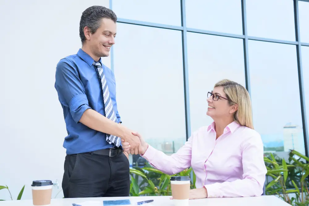A confident entrepreneur shaking hands with a finance consultant after securing a business loan in Australia.